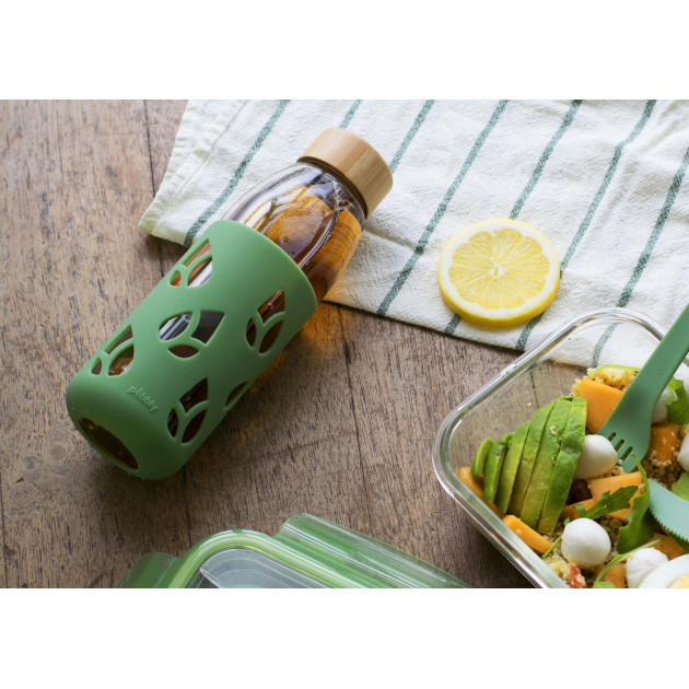 Mise en situation Pebbly : bouteille en verre vide avec protection en silicone vert sauge et bouchon bambou Mise en situation Pebbly : bouteille en verre vide avec protection en silicone vert sauge et bouchon bambou